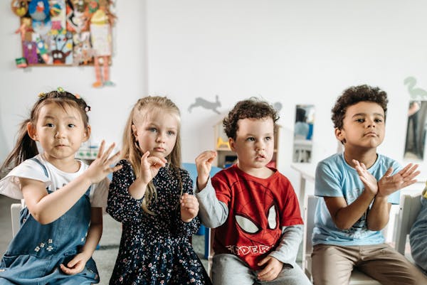 Four preschoolers seated in a kindergarten classroom